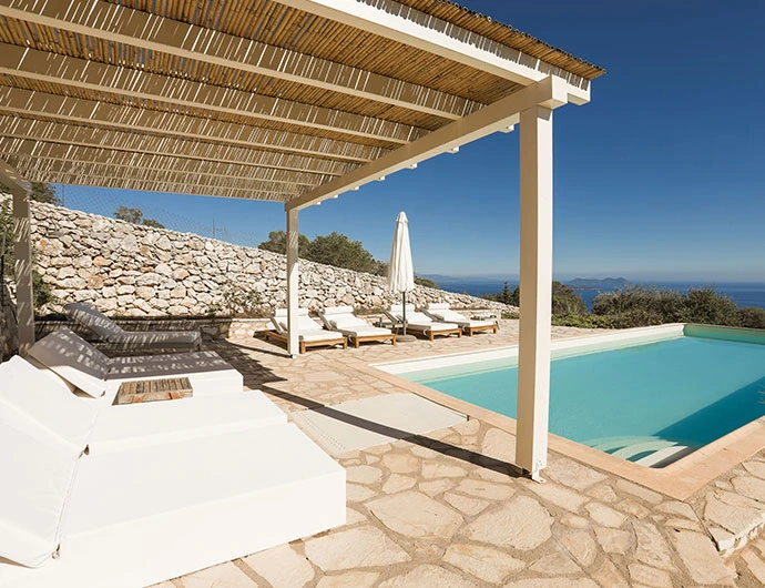 Pool view with the bamboo pergola and the pillow sunbeds facing the Ionian sea in Lefkada island