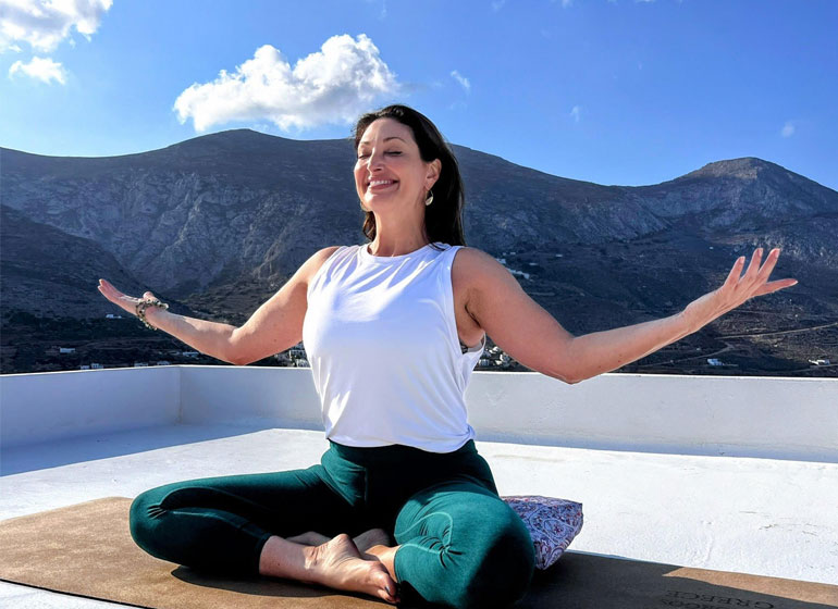 Amanda Trevelino Yoga instructor practicing while facing the Greek blue skies.